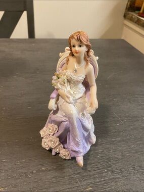 A girl sitting with a flowers bouquet figurine